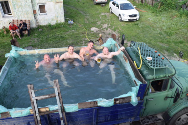 мужчины купаются в ЗИЛе с водой