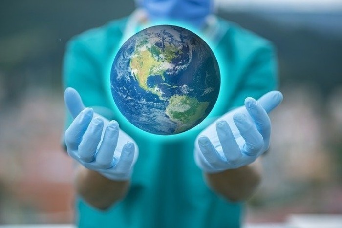 врач держит в руках планету