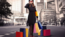Девушка с покупками на фоне городской застройки